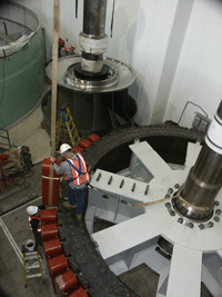 Installing refurbished hydrogenerator field poles.